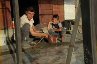 A father teaches his son tile making.