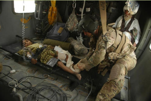 Sgt. Eric Papp, of the Minnesota National Guard, is attending to leg wound of a little Afghan girl injured in an IED blast.